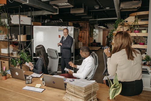 Free A Man in Corporate Attire Talking at a Meeting in an Office Stock Photo