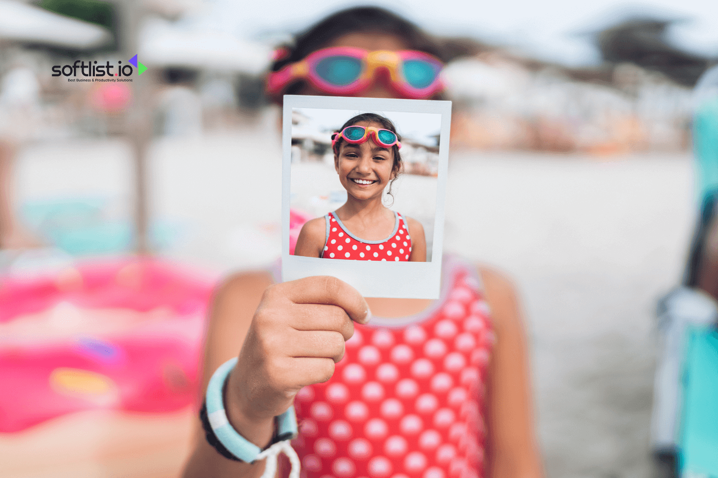 Little girl with swimming googles showing instant photo