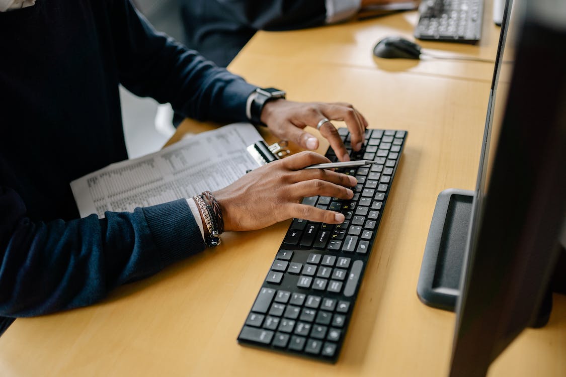 Free A Person Typing on a Wireless Keyboard Stock Photo