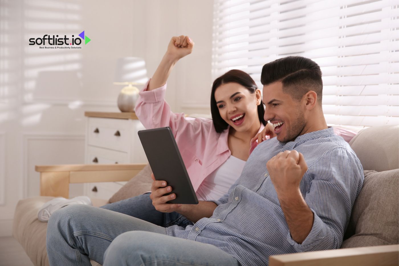 a man and woman happy looking their tablet