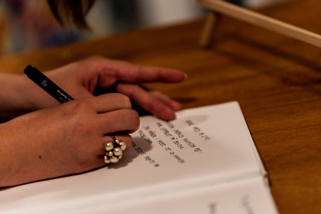 Close-up of Woman Writing in a Notebook