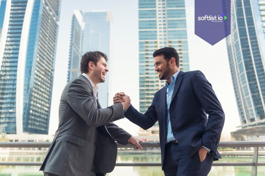 Two businessmen shaking hands confidently, representing creative deal structures in business agreements.