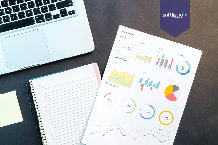 Laptop, notebook, and printed charts with graphs and pie charts on a desk, representing buying an online business as an individual.