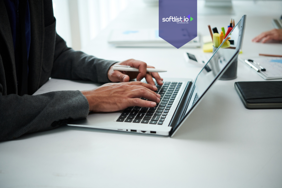 Close-up of a person in a suit typing on a laptop at a desk, representing buying an online business as an individual.
