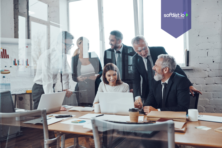 Business team gathered around a laptop in a modern office, discussing community-driven business valuation strategies and engagement insights.