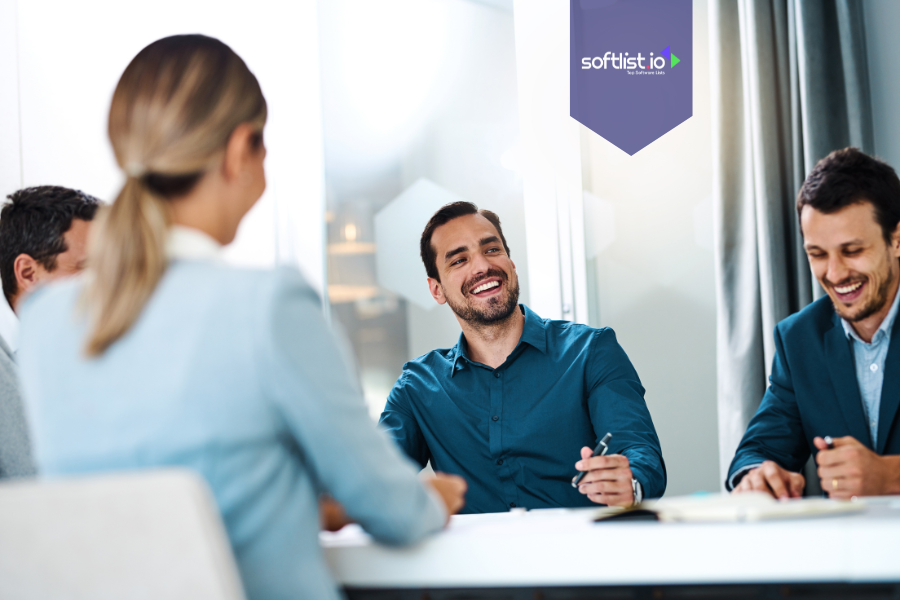 Group of professionals in a meeting, smiling and taking notes, representing community-driven business valuation through team collaboration and shared insights.