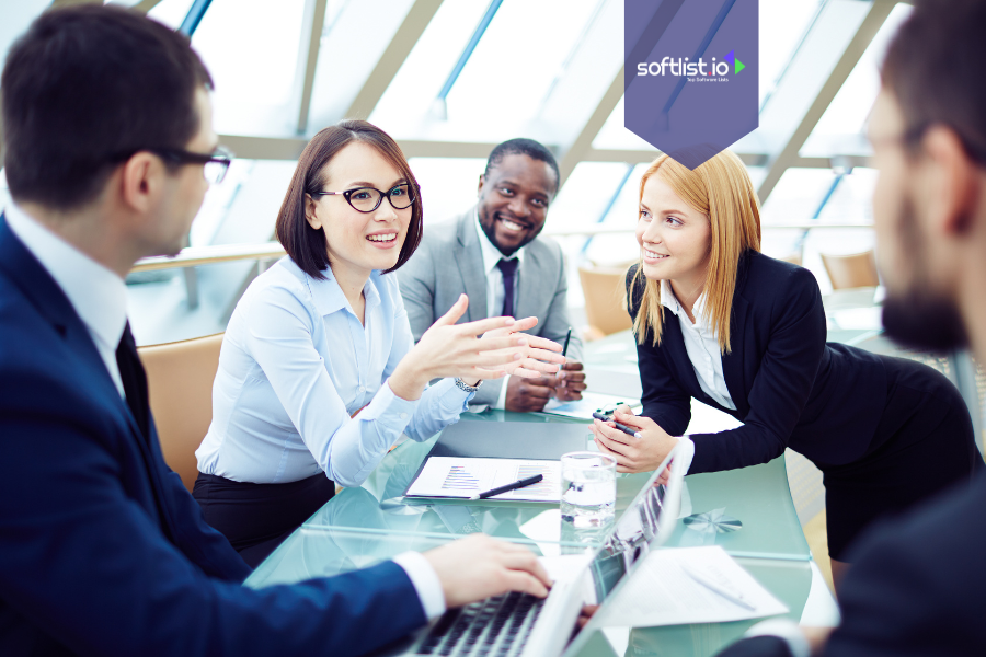 Group of diverse business professionals engaged in a team discussion around a glass table, illustrating community-driven business valuation strategies.