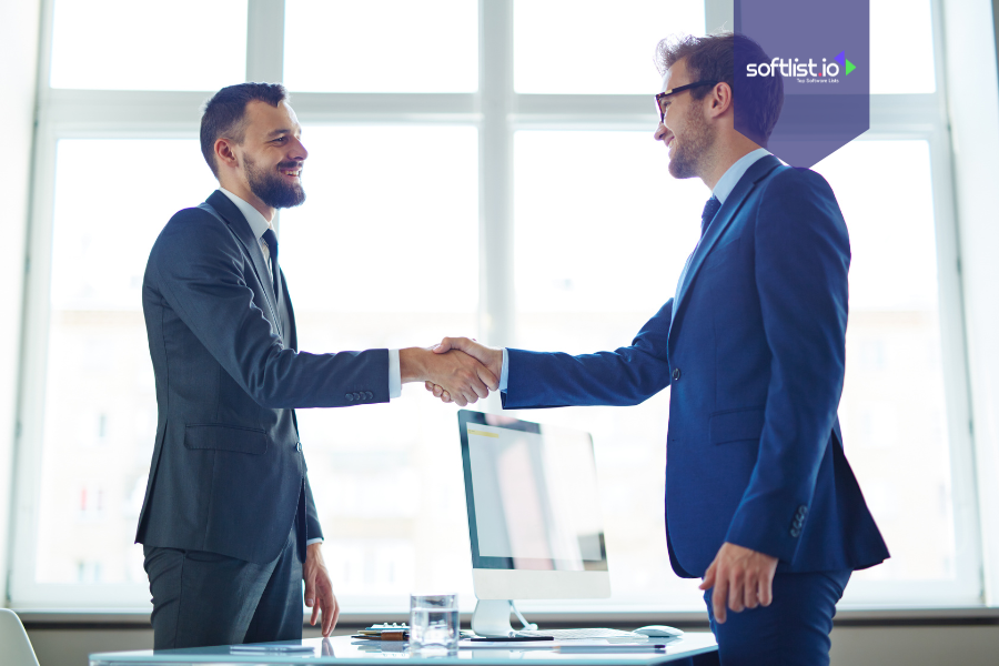 Two businessmen shaking hands in an office, symbolizing creative deal structures and successful business agreements.