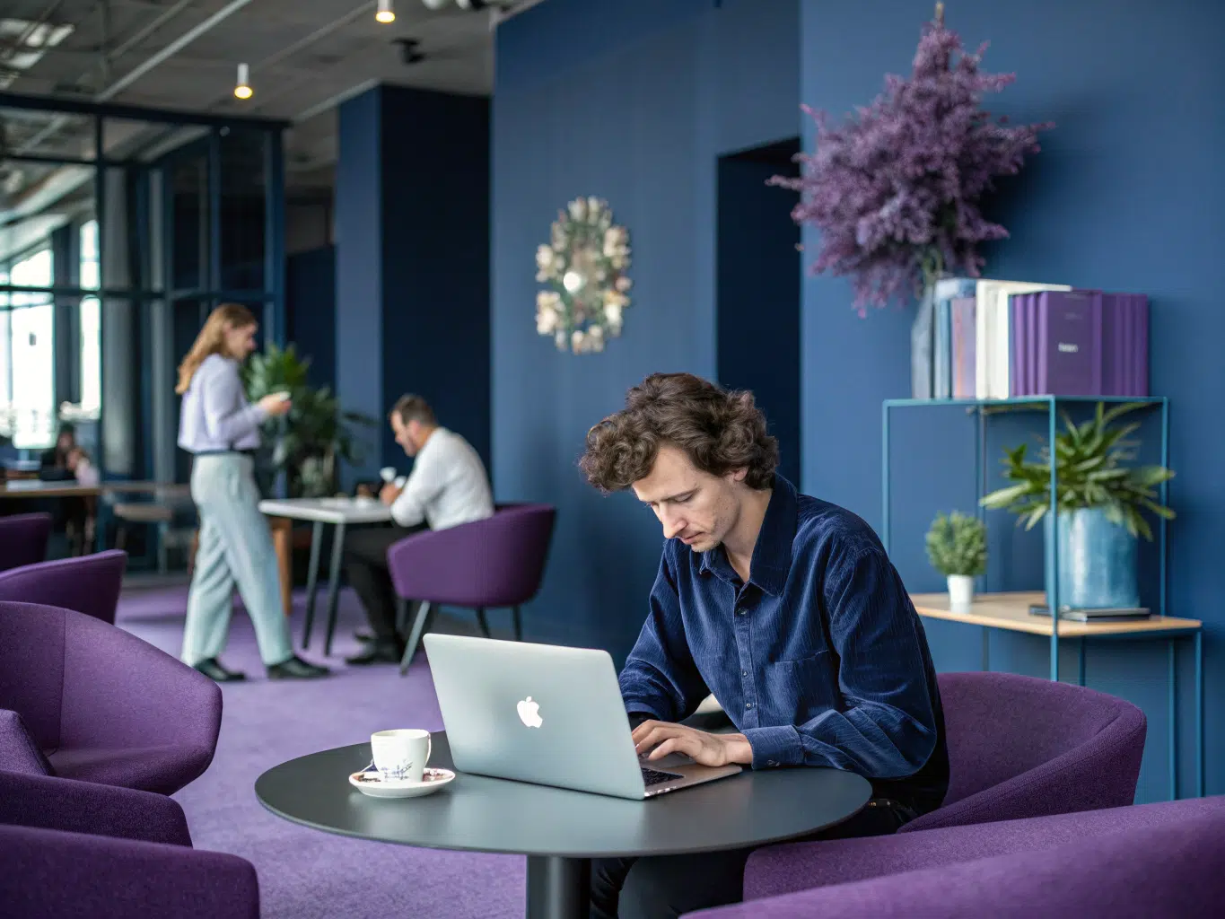 Professional works on laptop in collaborative workspace illustrating CRM software types.